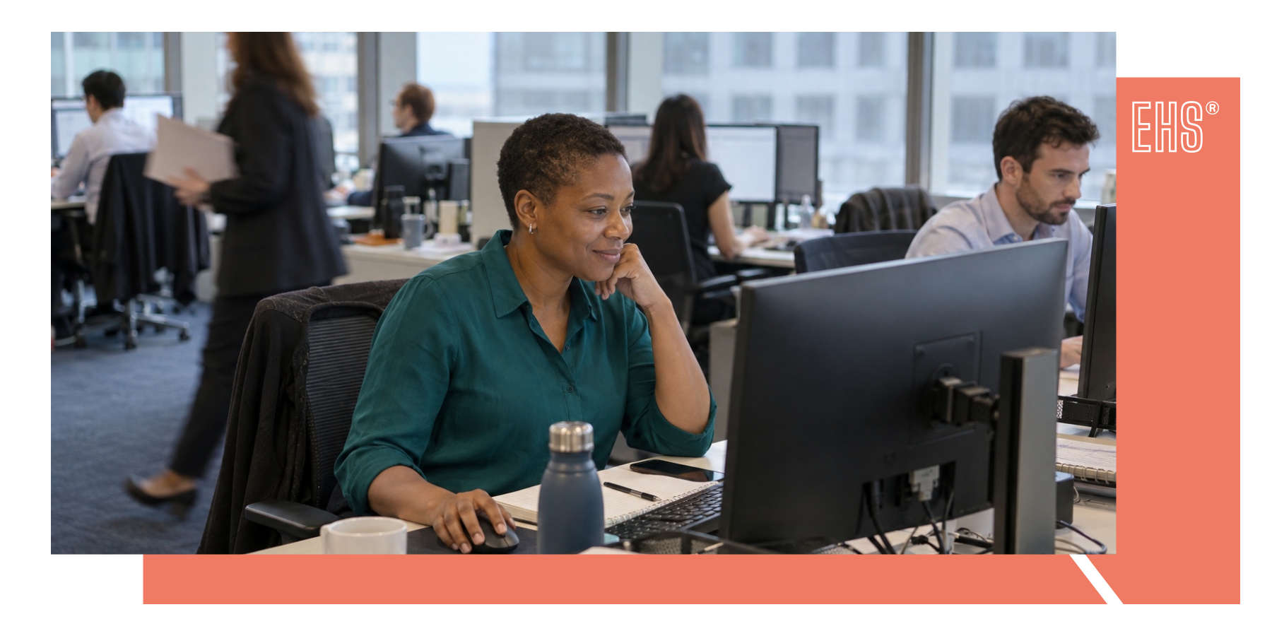 Employee reviewing information at an office computer with EHS branding