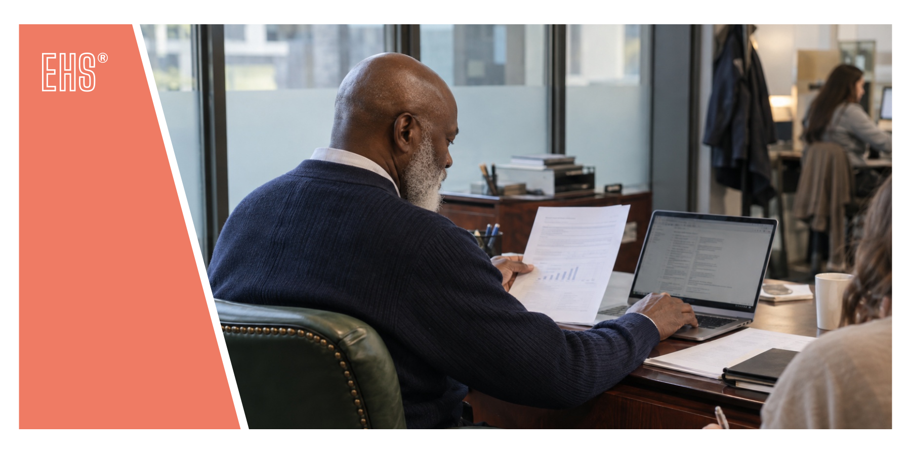 Employee reviewing a report at a desk with EHS branding